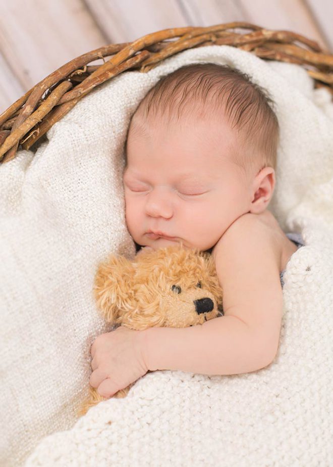 Schlafendes Baby hält Teddy im Arm